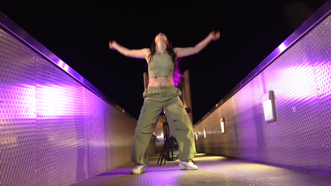 Woman dancing on a bridge at night