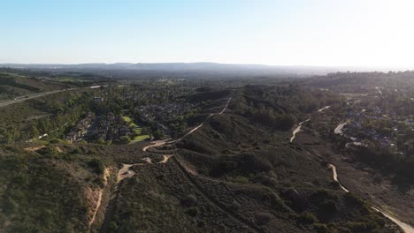 majestuosa vista de las colinas con senderos, vecindario suburbano en la distancia