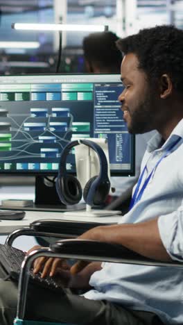 Vertical Video Data Center Engineer In Wheelchair And Coworkers Fighting Security Breach