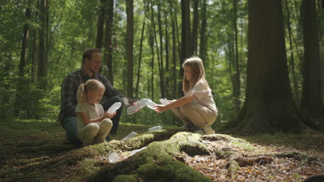 family cleaning up plastic bottles in the forest