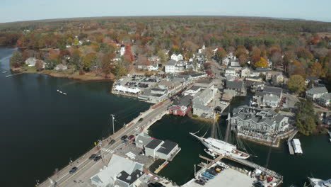 River-across-downtown-with-two-masted-sailboat-and-bridge,-drone-shot,-Kennebunkport-ME