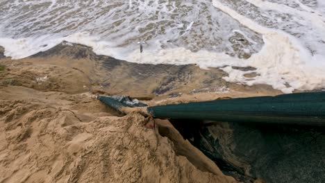 coastal erosion at surfers paradise, showing waves impacting the shoreline and causing significant sand displacement