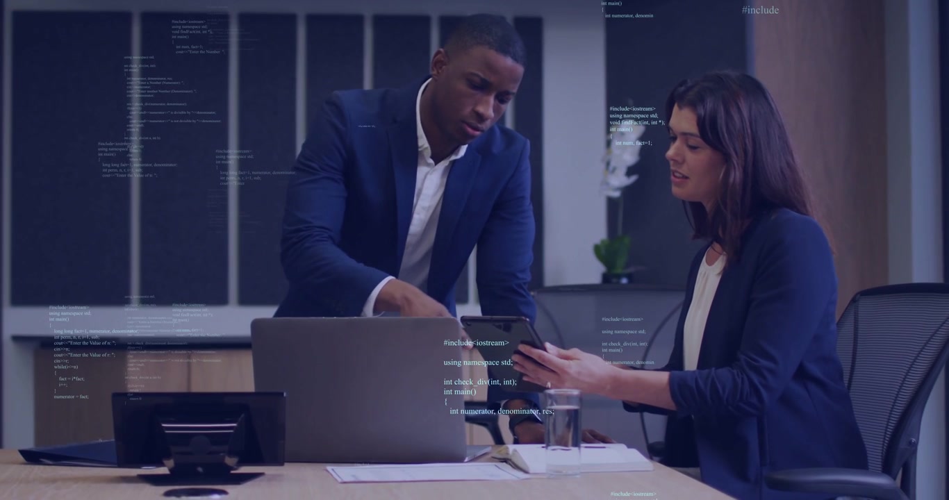 Man leaning in, woman rotating tablet, man pointing, both reviewing UI code overlay for tech review