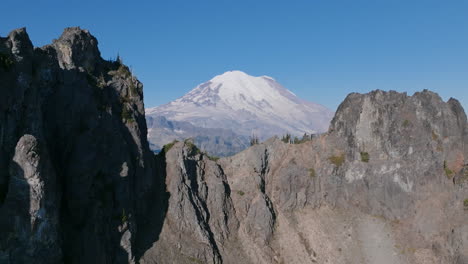 images aériennes volant à travers les crêtes rocheuses des montagnes en cascade avec le mont rainier en arrière-plan