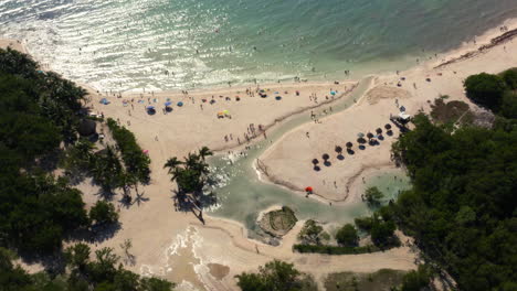 Paraíso-De-Playa-De-Arena-Tropical-Con-Laguna-Y-Vacacionistas-Relajantes