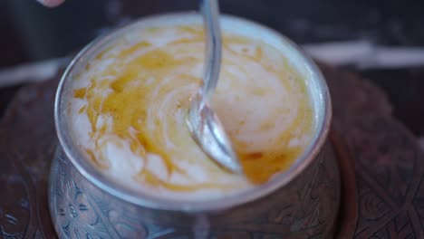 close-up of creamy yogurt with honey in a metal bowl