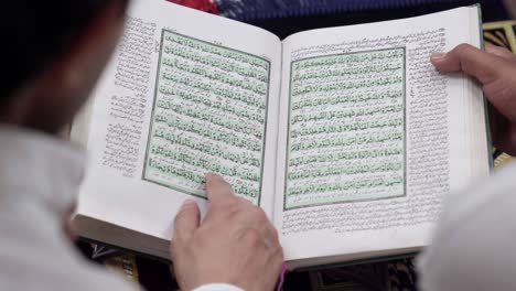 close up shot of indian people reading holy book quran