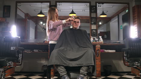 rear view of man client visiting haidresser and hairstylist in barber shop.