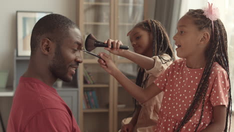 sisters putting makeup on fathers face