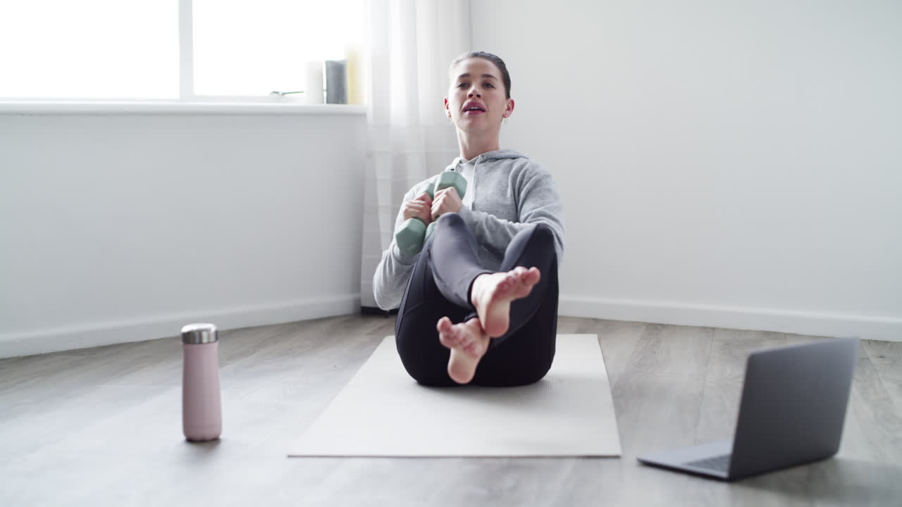 una mujer joven usando una computadora portátil mientras hace ejercicio