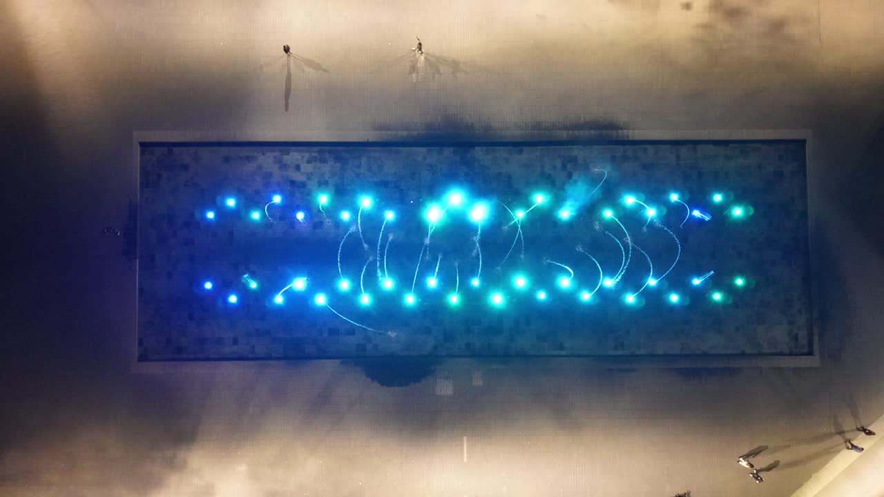 Drohnen-Übersichtsaufnahme eines Platzbrunnens mit bunten Lichtern bei Nacht, CDMX