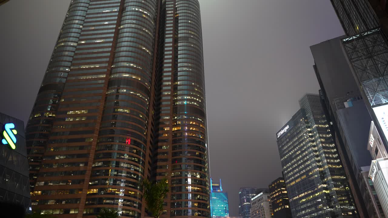 Illuminated skyscrapers in Hong Kong's financial district at night. Low-angled view