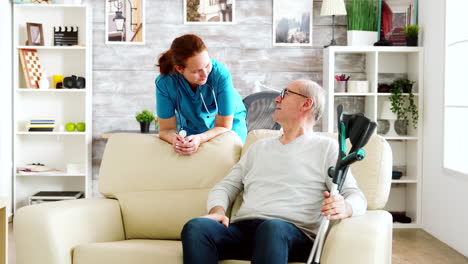 retired man in nursing home talking with a nurse