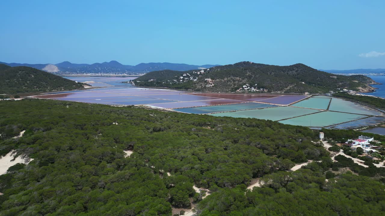 colorful salt flats of Ibiza with the Mediterranean vegetation in the foreground. Nice aerial view flight wide orbit overview drone