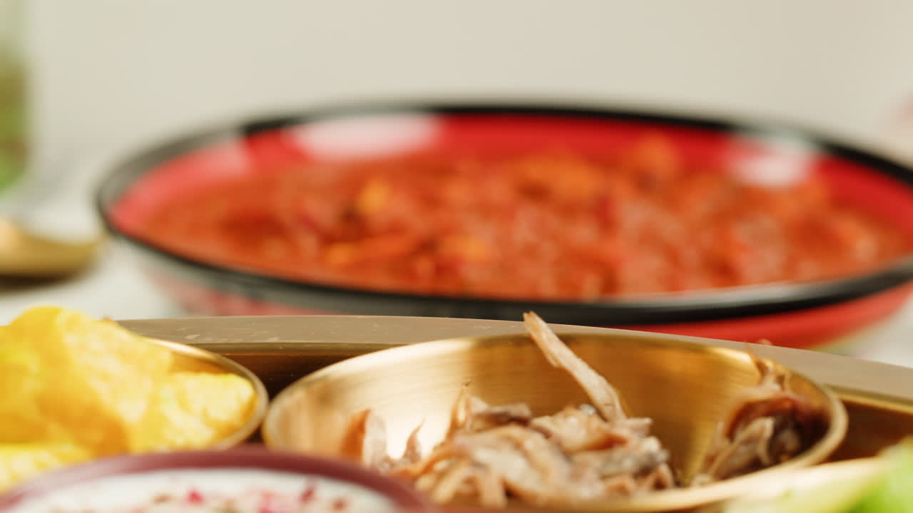 Assorted indian sri-lanka food set on wooden background. Dishes and appetisers of indeed cuisine, rice, lentils, paneer, samosa, spices, masala. Bowls and plates with indian food top view chicken. High quality 4k footage