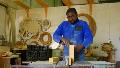 male working on wooden block in workshop 4k