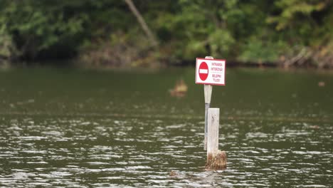 no entry sign on the wooden pole at red lake in romania