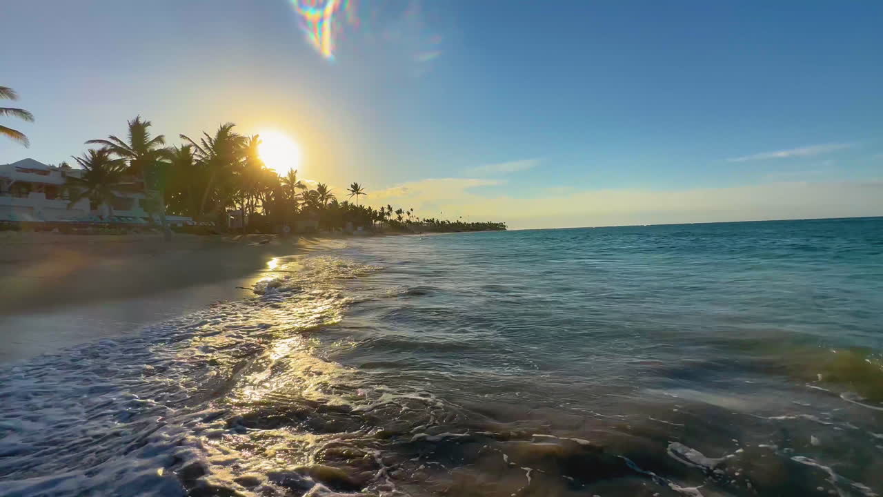 O sol poente refletindo nas ondas na costa de Punta Cana, ilha dominicana de Hispaniola