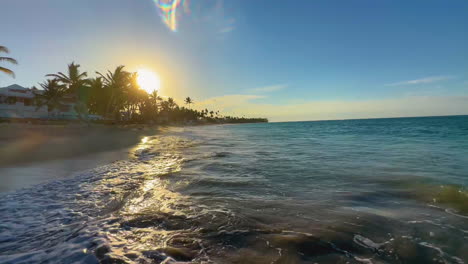 the-setting-sun-reflecting-off-the-rolling-waves-on-the-shore-of-Punta-Cana,-Dominican-island-of-Hispaniola