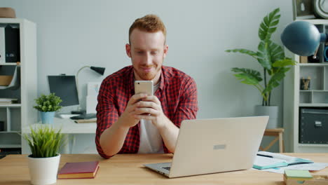 man using smartphone and laptop in an office setting