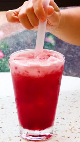 persona agitando y bebiendo jugo de sandía