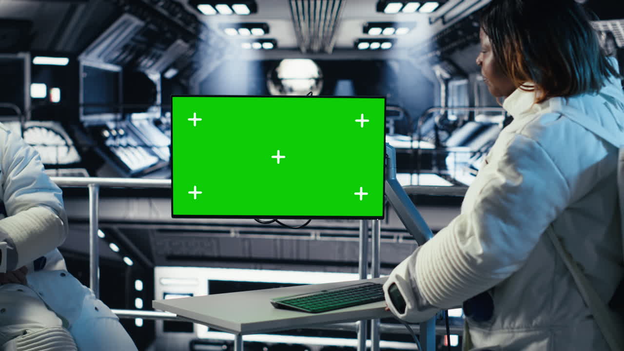 Astronauts checking human expansion in space mission logs on mockup monitor