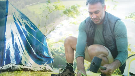 setting up tent, man camping over scenic landscape