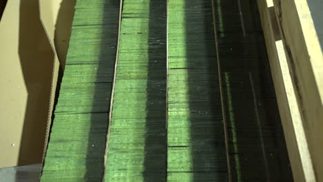 small glass panels stacked in wooden box