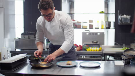 chef preparing orders in restaurant kitchen