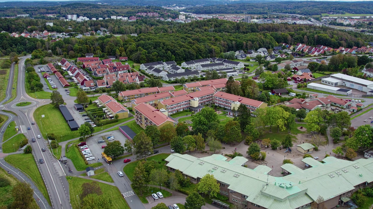 Aerial drone view shows residential area in Kungalv with apartment buildings houses streets parking and green spaces in organized suburban neighborhood landscape