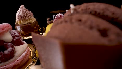 Macro-view-of-turning-Patisserie-cakes-on-black-reflective-glass-background,-4k-luxury-desserts