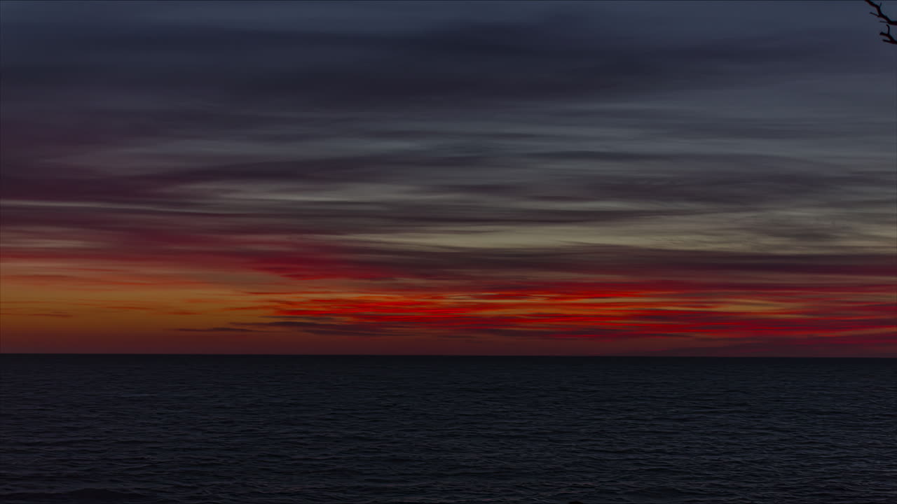 일몰 시 황금색 톤이 있는 불 같은 하늘이 어둠으로 바뀝니다.