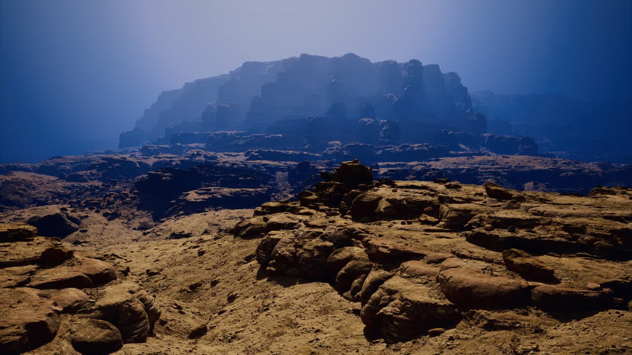 Desert landscape with rocky formations and distant mountains in twilight