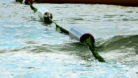 closeup of buoy barrier on rough sea surface swing on waves. people protect from boat