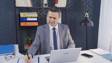 Office-worker-man-working-on-laptop-at-his-desk.