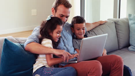 happy father with two children using laptop