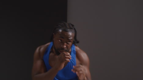 studio shot of male boxer training in gym sparring and sweating warming up preparing for fight 2