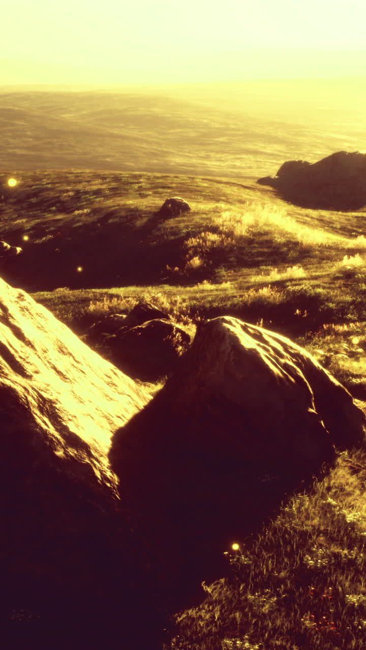 Scenic view of sunlit hills and distant landscape during golden hour