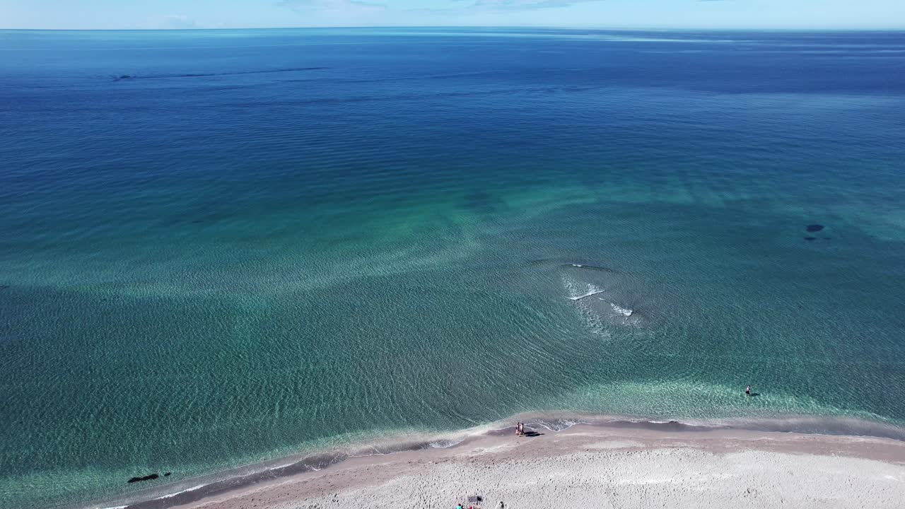 해변은 파란색과 투르코이즈색의 물로 바다의 멋진 전망을 제공합니다. 이것은 자연의 아름다움을 감상하기에 완벽한 장소입니다.