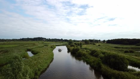 Imágenes-Aéreas-De-Drones-De-Un-Barco-Que-Viaja-A-Lo-Largo-Del-Reflejo-Del-Río-Yare-En-Norfolk-Broads