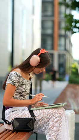 mujer joven dibujando en una tabla en la ciudad