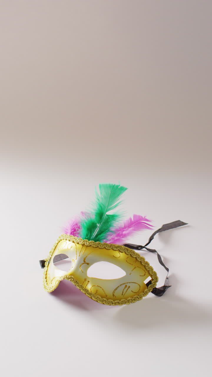 Video verticale di maschera di carnevale con piume su sfondo bianco con spazio per il testo.