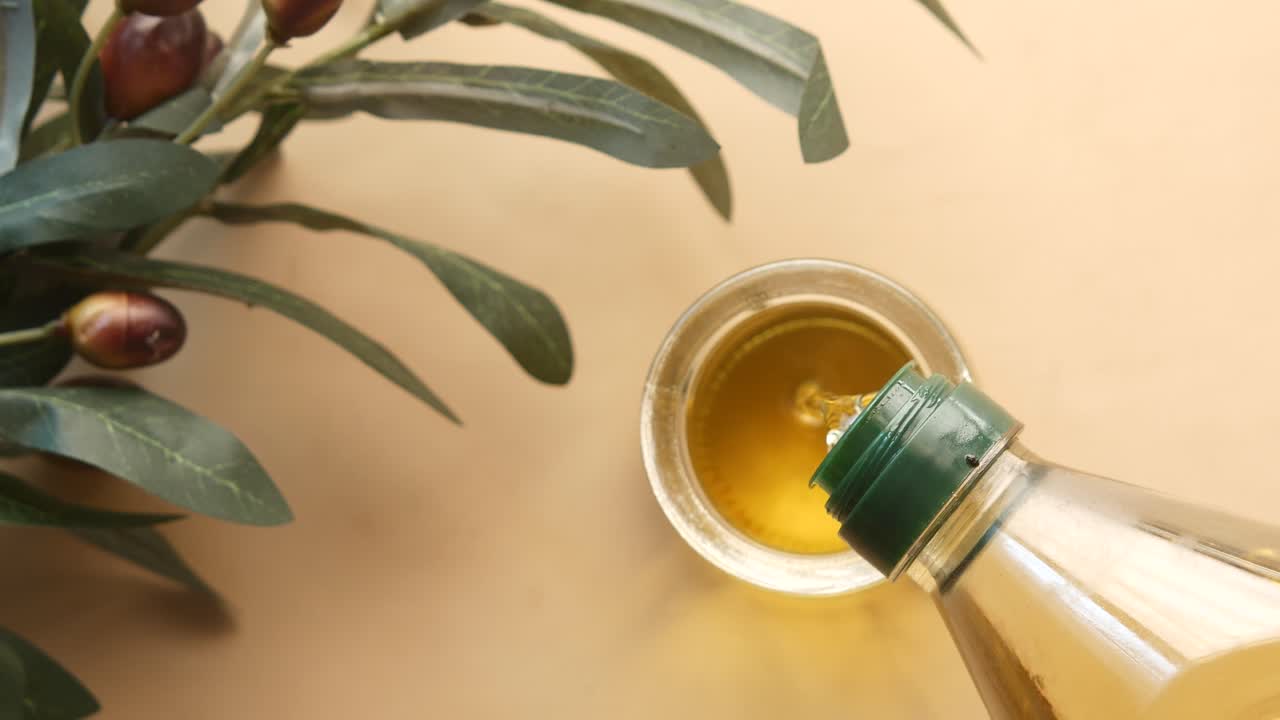Pouring Olive Oil From Bottle Into Glass