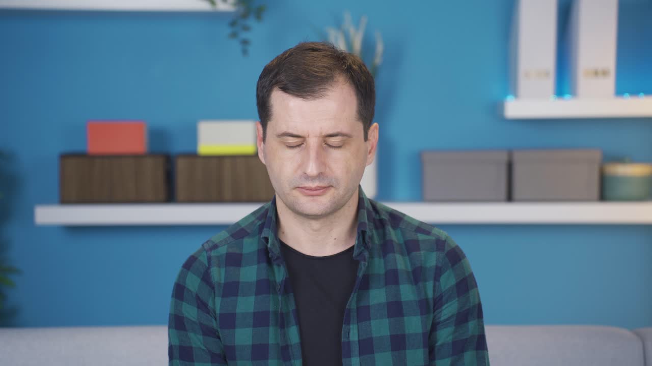 부정적인 남자가 집에서 고개를 끄덕이고, 실패하고, 나쁜 소식에 화가 납니다.