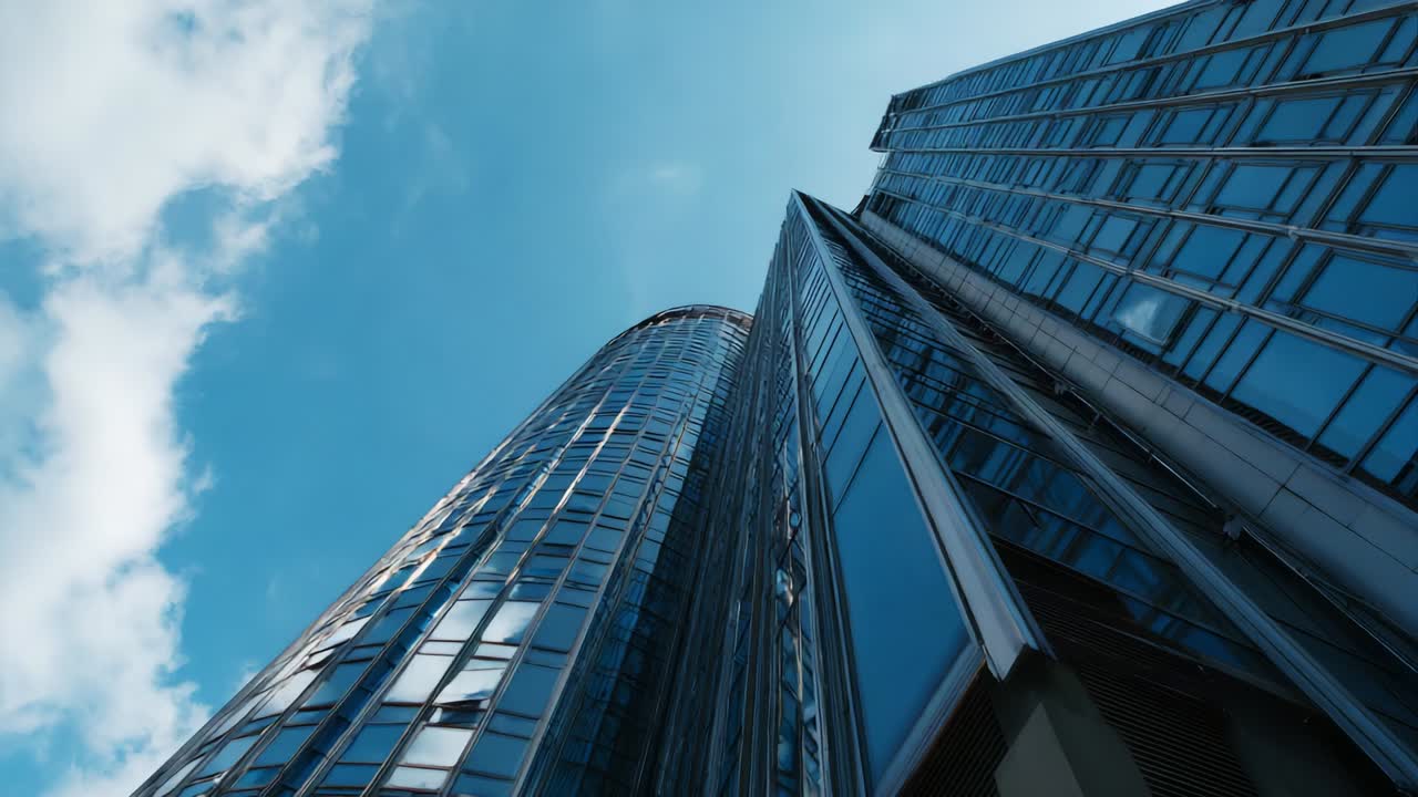 A stunning upward view of a modern skyscraper showcasing a glass facade, reflecting the vibrant sky while emphasizing the architectural brilliance and urban design in contemporary city landscapes