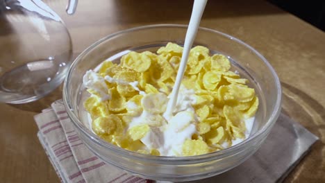 Crispy-yellow-corn-flakes-into-the-bowl-for-the-morning-a-delicious-Breakfast-with-milk.-Slow-motion-with-rotation-tracking-shot.