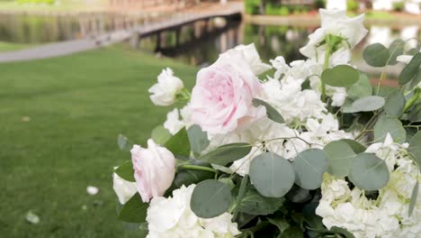 el viento acaricia un ramo de flores cerca del río con el puente en el fondo
