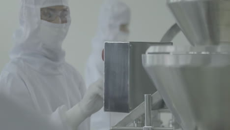 lab workers in washing gloves on the blurred background of the production line. scientist hand working in laboratory. science, chemistry and medicine concept. pharmacist making medicines
