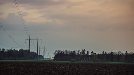 Endlose-Stromleitungen,-Die-Sich-über-Die-Landwirtschaftliche-Landschaft-Erstrecken,-Zeitrafferansicht