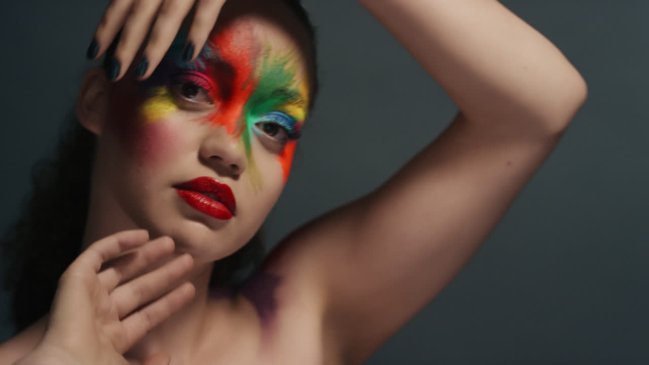 retrato de cerca de una mujer hermosa con una pintura de rostro colorida arte corporal multicolor exótico mujer sensual que disfruta de la expresión creativa
